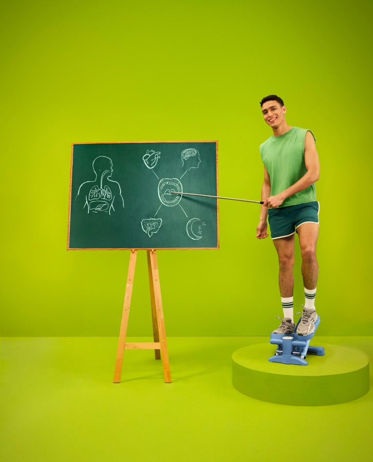 Un uomo in abbigliamento sportivo che indica un diagramma del corpo su una lavagna a gesso